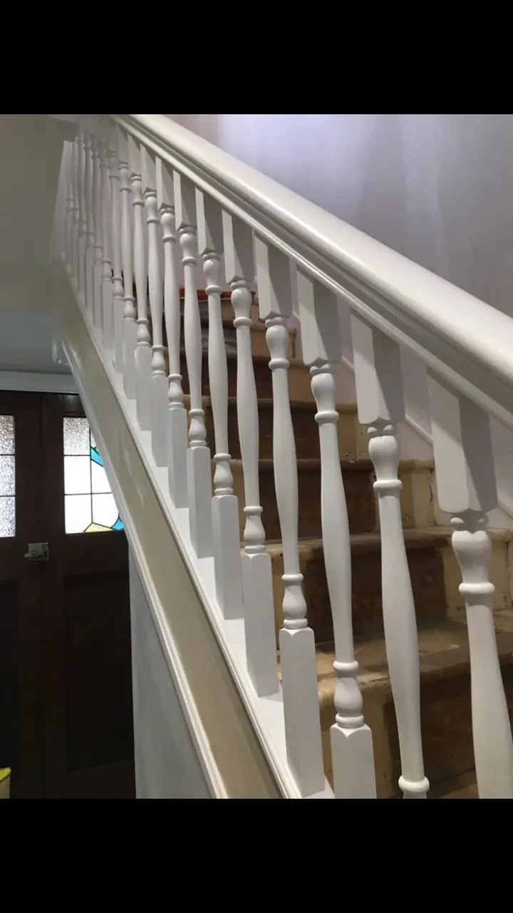 Crouch End period stairwell with restored white balusters, stained wooden treads and warm white walls